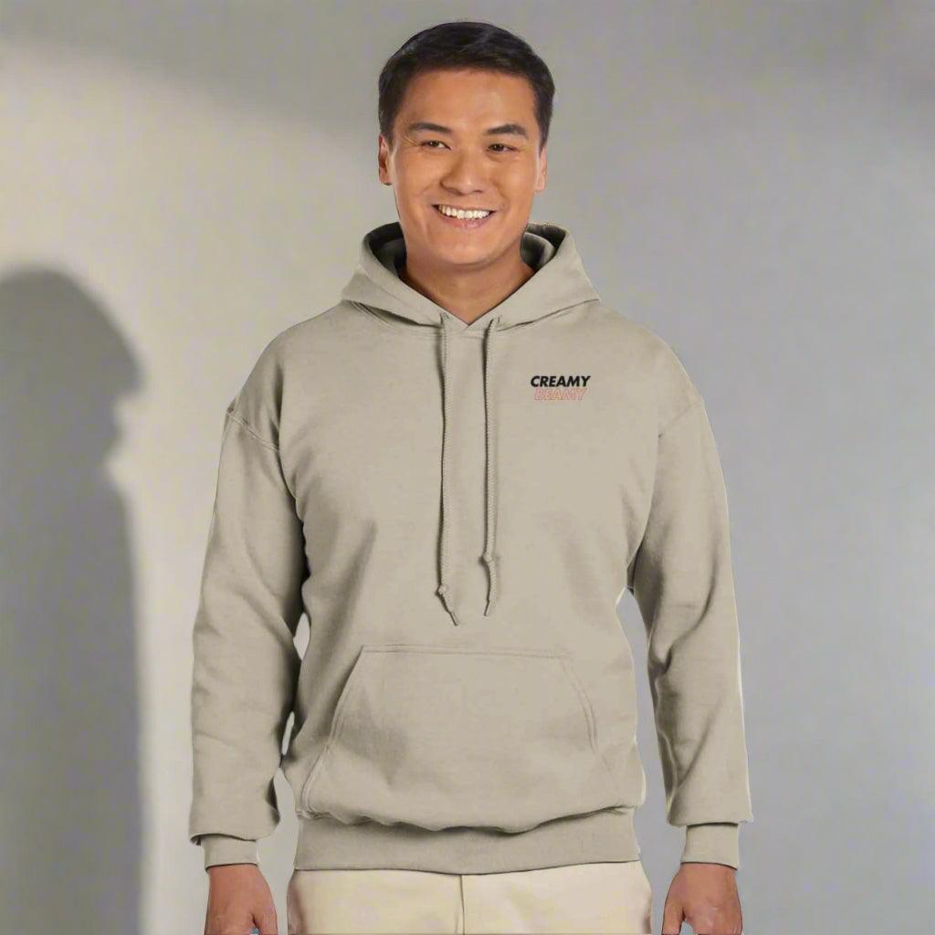 Man modeling a cream hoodie with 'CREAMY' logo, showcasing Beamish Irish Stout style.