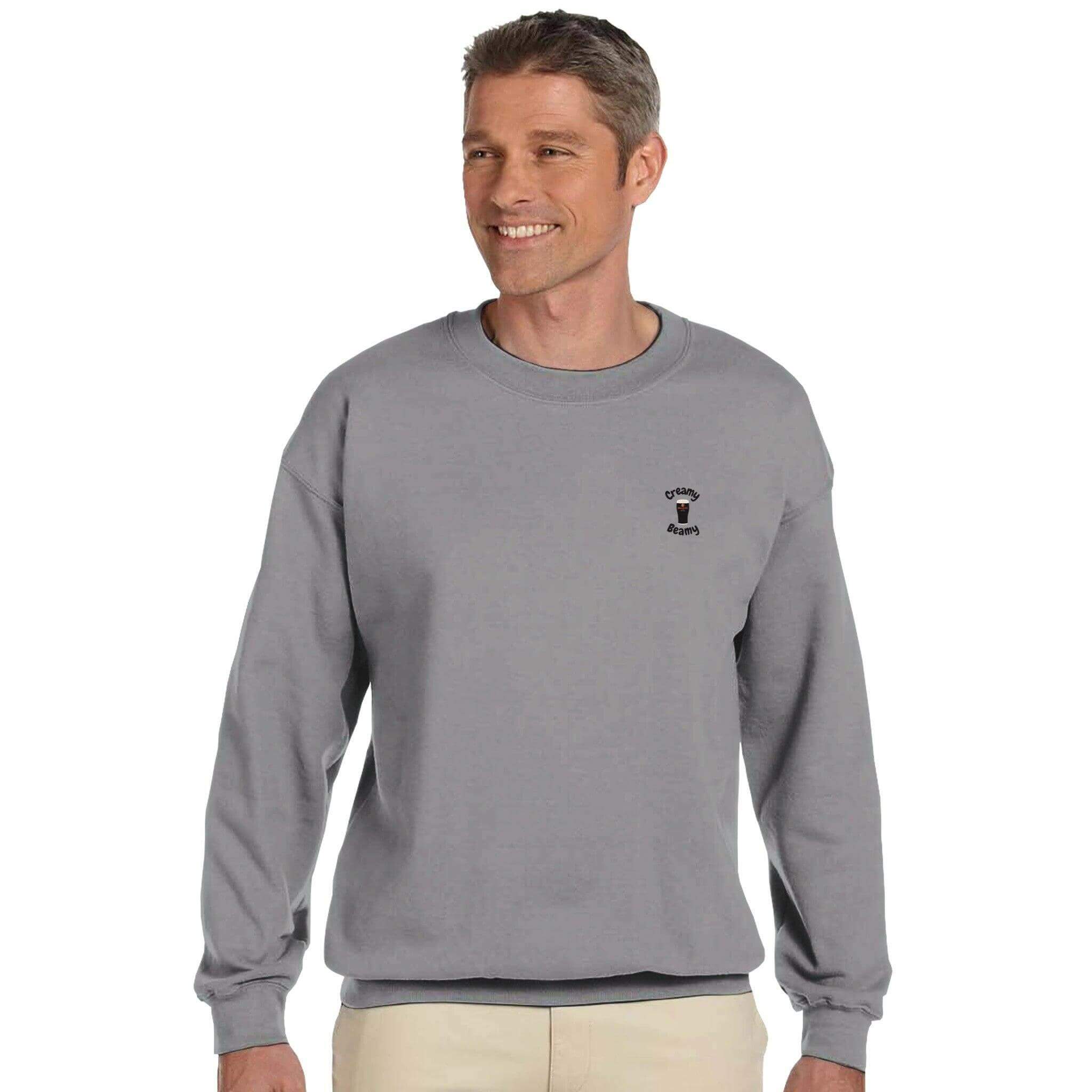 Smiling man wearing a gray Creamy Beamy Beamish Irish Stout Sweatshirt, showcasing comfort and casual style.
